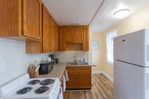 杰克逊维尔海滩NEW Listing! Centrally Located Property! Close to Everything!的厨房配有木制橱柜和白色冰箱。