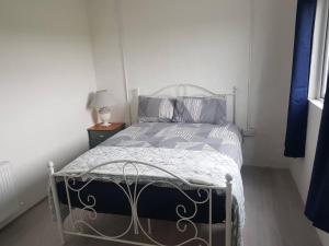 特拉利Lavender lane cottage的一间卧室配有一张带蓝色和灰色枕头的床