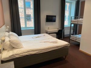 耶夫勒Ahlgrens Hotell Bed & Breakfast的一间卧室配有一张大床、一张桌子和一张四柱床。