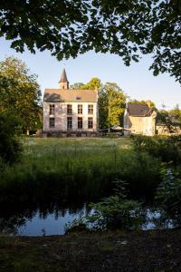 达默Treehouse 'Morgenrood' Ryckevelde 1451的一座老石屋,池塘里映照着