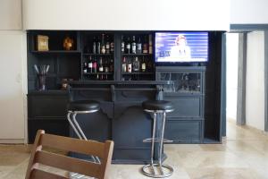Mirandol-BourgnounacLa maison Cayré的一间酒吧,里面设有凳子和电视