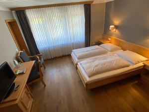 汉恩明登福拉克斯韦拉塔生态酒店的一间卧室配有一张床、一张书桌和一台电视