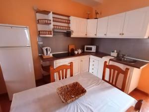 Valles de OrtegaCasa Palmés的厨房配有白色橱柜和桌椅
