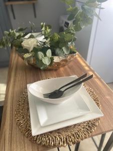 格罗斯岛Keikei’sHaven的一张桌子,上面有盘子和叉子,还有一碗鲜花