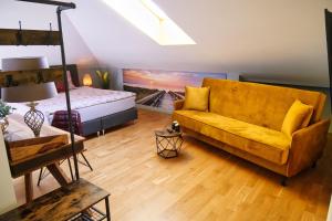 伦堡Villa Pro Musica - apartamenty, śniadania的客厅配有黄色的沙发和床。