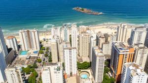 瓜鲁雅Ferraretto Guarujá Hotel & Spa的享有城市的空中景色,拥有海滩和建筑