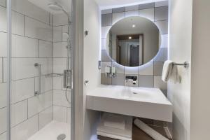 都柏林Hampton By Hilton Dublin City Centre的白色的浴室设有水槽和镜子