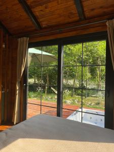 ArdeşenNoveli Tiny House的卧室设有通往庭院的大玻璃门。