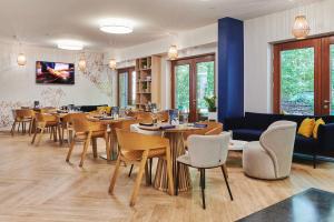 米兹多洛杰金郁金香扎科帕公寓酒店的餐厅设有桌椅和沙发。