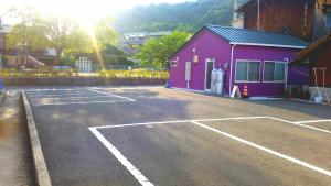 直岛町雅多七海滩酒店的紫色建筑前的停车场