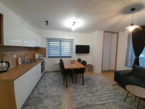 别拉什尼察Apartment Bjelasnica DAH的厨房以及带桌子和沙发的客厅。