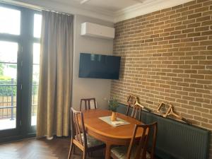 伦敦Queens View的一间设有木桌和砖墙的用餐室