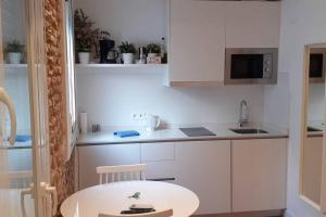 马德里Cozy studio in Madrid Rio with backyard-EM-ISA-A2的白色的小厨房配有桌子和水槽