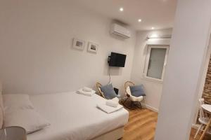 马德里Cozy studio in Madrid Rio with backyard-EM-ISA-A2的白色的客房配有一张床和两把椅子