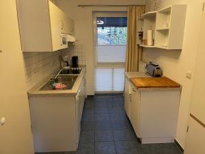 科瑟罗Seeblick Wohnung 113 mit teilw Meerblick的小厨房配有白色橱柜和水槽