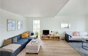 VågeNice Home In Stolmen With House Sea View的客厅配有蓝色的沙发和桌子