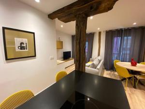 毕尔巴鄂Apartamento Deluxe Casco Viejo的客厅配有黑桌和黄色椅子