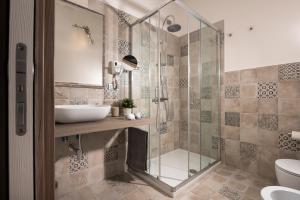 奥罗塞伊Hotel Gli Ulivi的一间带玻璃淋浴和水槽的浴室