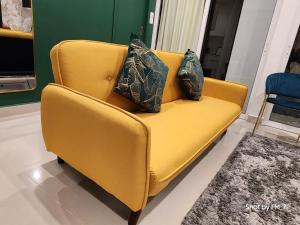 哥打京那巴鲁Seaview Luxury Suites at The Shore Kota Kinabalu的一张黄色的沙发,里面有两个枕头