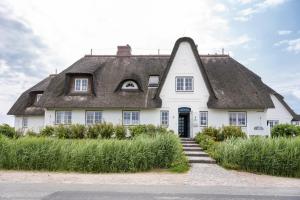 兰图姆Strandvogtei Sylt的一座带茅草屋顶的大型白色房屋