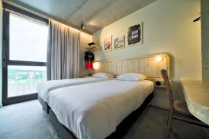 塞尔奈greet hotel Cernay Mulhouse的一间卧室设有一张大床和一个窗户。