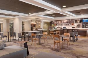 格林维尔格林维尔斯巴坦堡机场万怡酒店的一间带桌椅的餐厅和一间酒吧