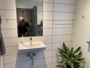 GræstedØrbakke的一位女性拍着带水槽的浴室的照片