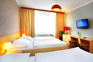 布拉格查尔斯中央酒店的酒店客房设有两张床、一张书桌和一个窗户。
