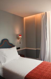 波尔图GRANDE HOTEL PARIS by STAY HOTELS的一间卧室配有一张带红色毯子的床和窗户。