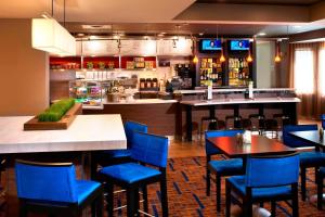 独立市克利夫兰独立万怡酒店的一间设有蓝色椅子的餐厅和一间酒吧