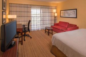 查尔斯顿Courtyard by Marriott North Charleston Airport Coliseum的酒店客房设有床和客厅。