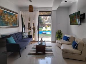 万查科Montemar Apart Hotel - Playa Huanchaco的客厅配有两张沙发和一张桌子