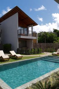 佩德拉斯港Alameda Lounge Pousada的一座带游泳池和房子的别墅