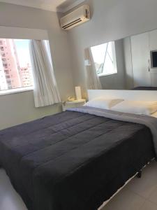 维多利亚Flat 704 Triângulo Apart的一间卧室设有一张大床和两个窗户。