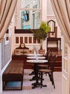 波尔图GRANDE HOTEL PARIS by STAY HOTELS的一间带桌椅和钢琴的用餐室