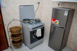 卡伦Classy African - themed 1 BR apartment in Karen的厨房配有炉灶和冰箱。
