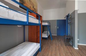 柏林柏林飞马酒店的宿舍间设有两张双层床和梯子。