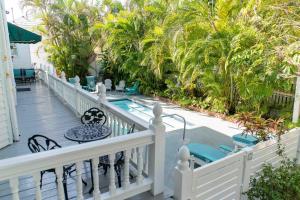 基韦斯特Southernmost Point Guest House & Garden Bar的阳台设有游泳池和棕榈树