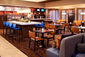 阿灵顿海茨芝加哥南阿灵顿海兹万怡酒店的一间带桌椅的餐厅和一间酒吧
