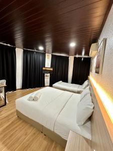 加央Kangar Hotel Sdn Bhd的配有黑色窗帘的客房内的两张床