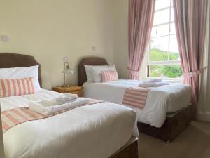 卡伦德Lubnaig Guest House的一间卧室设有两张床和窗户。