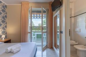 毕博纳的码头Hotel Riva Etrusca的酒店客房设有一张床和带阳台的浴室
