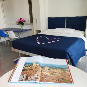 圣埃琳娜-迪西利亚Ca' Belvedere的一间酒店客房,配有一张床铺和一张桌子上的书籍