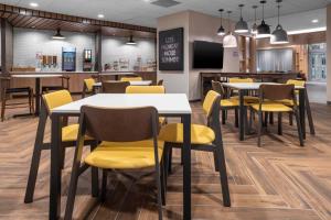 欧文达拉斯沃斯堡机场北/艾文费尔菲尔德客栈的用餐室配有桌子和黄色椅子