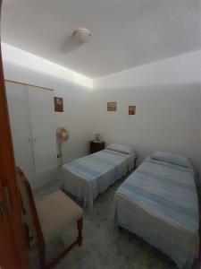 科尔萨诺Casa vacanze di Anna的一间设有两张床和椅子的房间