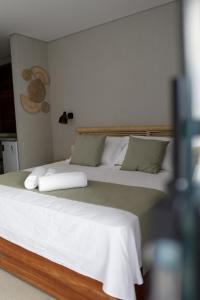 佩德拉斯港Alameda Lounge Pousada的一间卧室配有两张带白色床单和枕头的床。