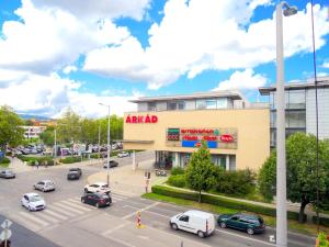 佩奇Árkád Apartman-Pécs的停车场内停车的商场的景色