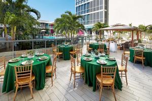 迈阿密The Gabriel Miami Downtown, Curio Collection by Hilton的庭院里配有带绿色桌椅的桌子