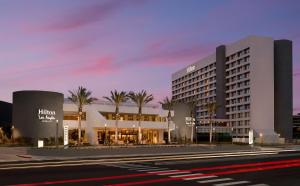 洛杉矶Hilton Los Angeles-Culver City, CA的街道前方有棕榈树的建筑