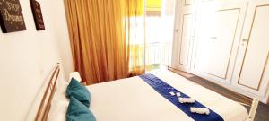 雅典Cozy room in quiet neighbourhood的一间卧室配有一张带蓝色床单的床和一扇窗户。